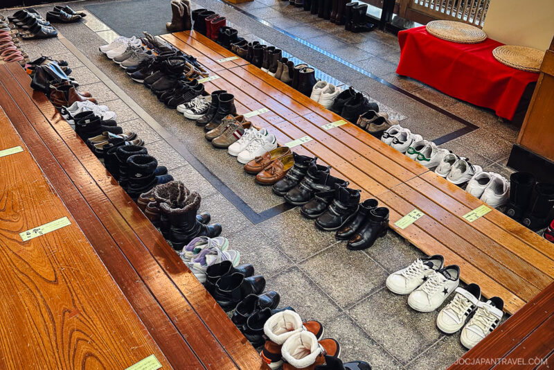 A row of shoes on a bench welcomes guests at Hotel Tachibana Shikitei, offering a glimpse into the inn’s serene hospitality.