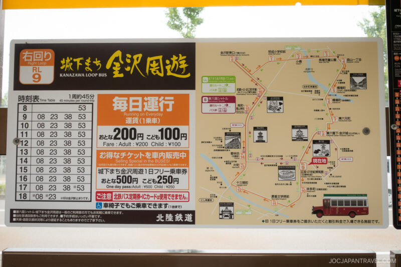 A sign displays the Kanzawa Loop Bus schedule, route map with local attractions, fare details for adults and children, and bus ticket information in both Japanese and some English.