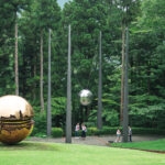 Hakone Open-Air Museum (箱根彫刻の森美術館): A Sculpture Wonderland in Nature Sculptures of reflective silver and gold spheres stand amid tall trees and grass at the Hakone Open-Air Museum, while several people walk nearby in an outdoor park surrounded by greenery.